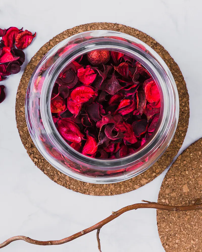 jar filled with deep red flower petals