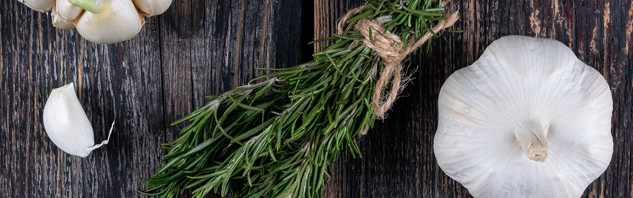 rosemary and garlic on wooden table