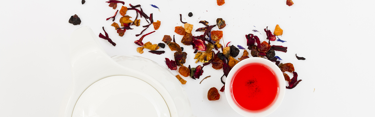 top view cup with red tea and red flower petals on white background