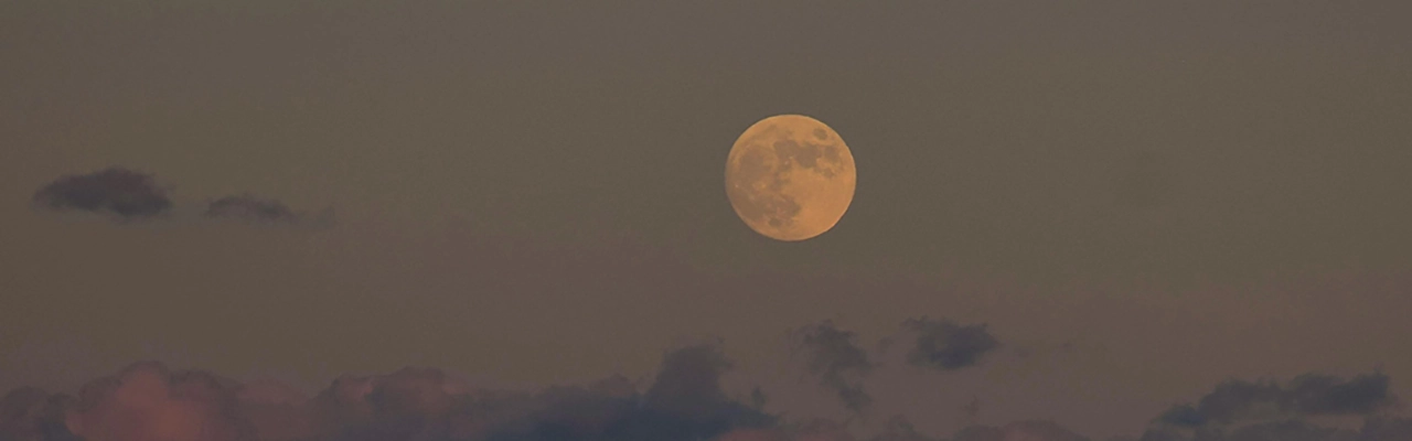 dark grey sky with full mooon and small clouds